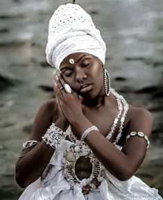 a woman in a white dress and headdress holding her hands to her face