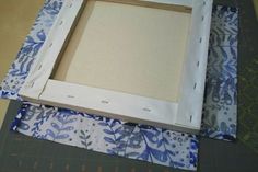 an open box sitting on top of a table with blue and white fabric around it