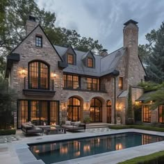 a large house with a pool in front of it and lots of windows on the side