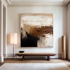 a large abstract painting hangs on the wall above a bench in a room with white walls