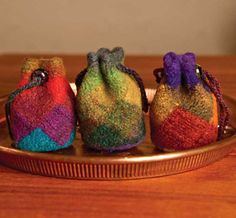 three small colorful bags sitting on top of a metal pan