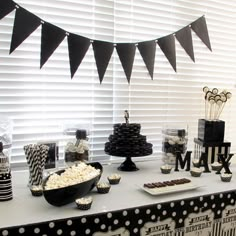 a black and white dessert table with cupcakes