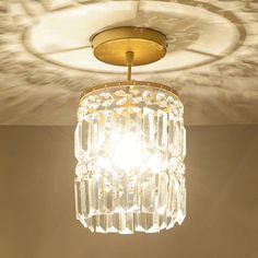 a chandelier hanging from the ceiling in a room with light shining on it