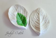 two white plates with green leaves on them