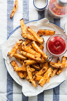 french fries on a plate with ketchup and sauce