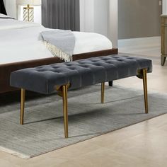 a large bed with a bench in front of it on top of a carpeted floor