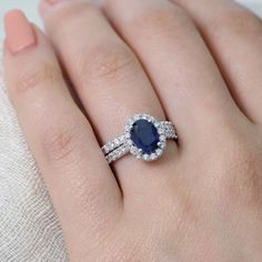 a woman's hand with a ring on it and a blue stone in the middle