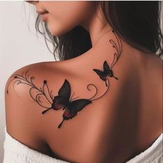 a woman's shoulder with two butterflies on it and an intricate vine around the neck