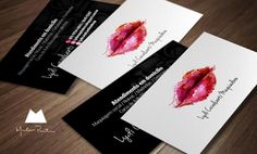 two business cards with red lips on them sitting on top of a wooden table next to each other