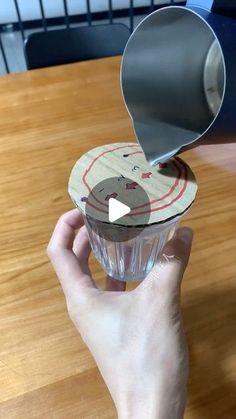 someone is pouring something into a small cup