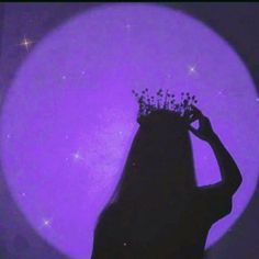 the silhouette of a woman wearing a tiara in front of a purple moon with stars