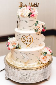 a wedding cake with flowers and initials on it