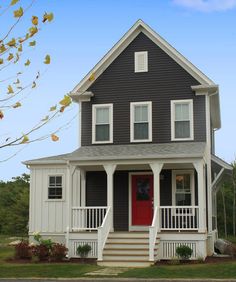 a black and white house with a red door