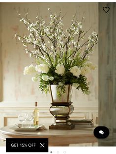 a vase filled with white flowers sitting on top of a table