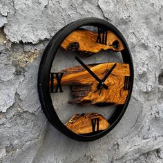 a clock made out of wood on the side of a stone wall with black hands