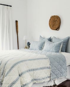 a bed with blue and white bedspread in a bedroom next to a window