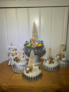 small christmas trees and ornaments in tins on a table