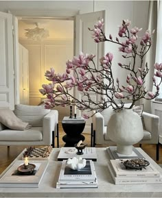 a living room filled with furniture and a large vase on top of a coffee table