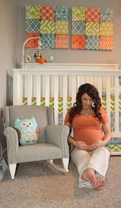 a woman sitting on the floor in front of a baby crib