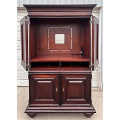 a large wooden cabinet with two doors on the front and one door open to reveal an empty shelf