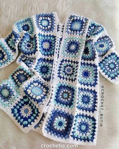 a crocheted blue and white afghan is laying on the floor