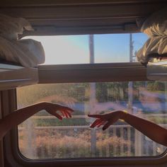 two hands reaching out the window to touch each other's hand in front of them