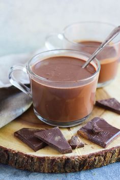 two cups filled with chocolate on top of a cutting board