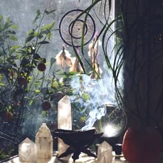 a table with candles, fruit and other items on it in front of a window