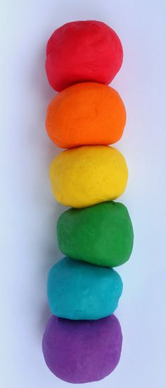 five colored rocks stacked on top of each other in the shape of a rainbow ball