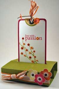 a card with flowers on it sitting on top of a green box and tag that says, be with passion