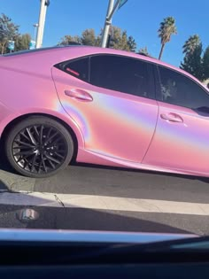 a pink car is parked in a parking lot