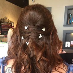 the back of a woman's head with hair pinned in half to her side