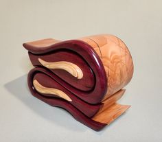 a wooden sculpture made to look like an abstract piece of wood with wavy curves and curved edges