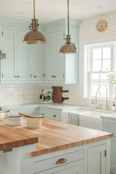 a kitchen with white cabinets and wooden counter tops