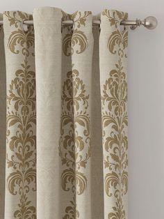 the curtains are hanging on the rod in front of the window with an ornate pattern