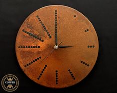 a clock that is on the side of a black surface with dots and lines in it