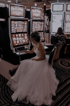 a woman in a wedding dress sitting at a slot machine and playing the casino games