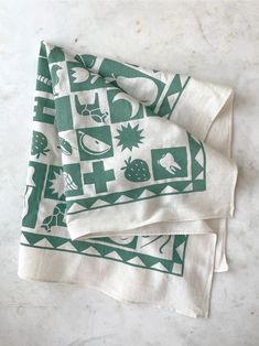 two green and white napkins sitting on top of a table next to each other