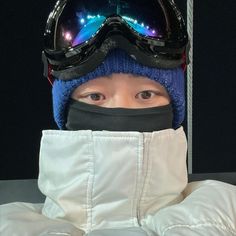 a young person wearing ski goggles and a hat with lights on it's face