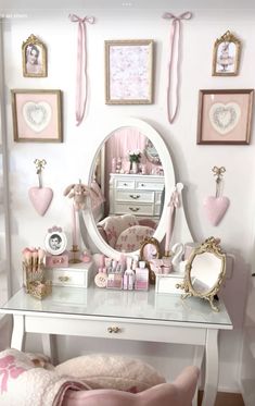 a white desk topped with a mirror and lots of pink decorations