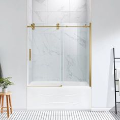 a white and gold bathroom with a marbled floor, shower stall and black and white tile