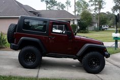 a red jeep parked in front of a house