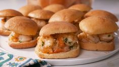 several small sandwiches on a plate next to some condiments