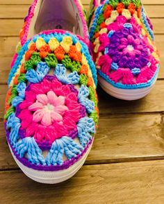 colorful crocheted slippers on wooden floor with white soles