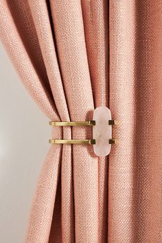 a pink curtain with gold rings on it