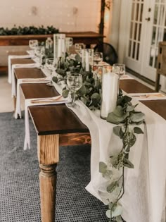 a long table with candles and greenery on it