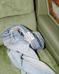 a pair of jeans sitting on top of a green chair