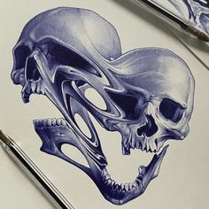 two drawings of skulls on paper with paintbrushes