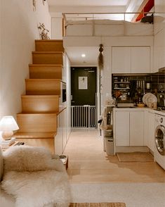 the stairs lead up to the kitchen and living room in this small apartment with white walls