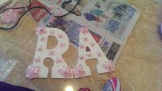 the letters are decorated with pink flowers and ribbons, along with other items on the floor